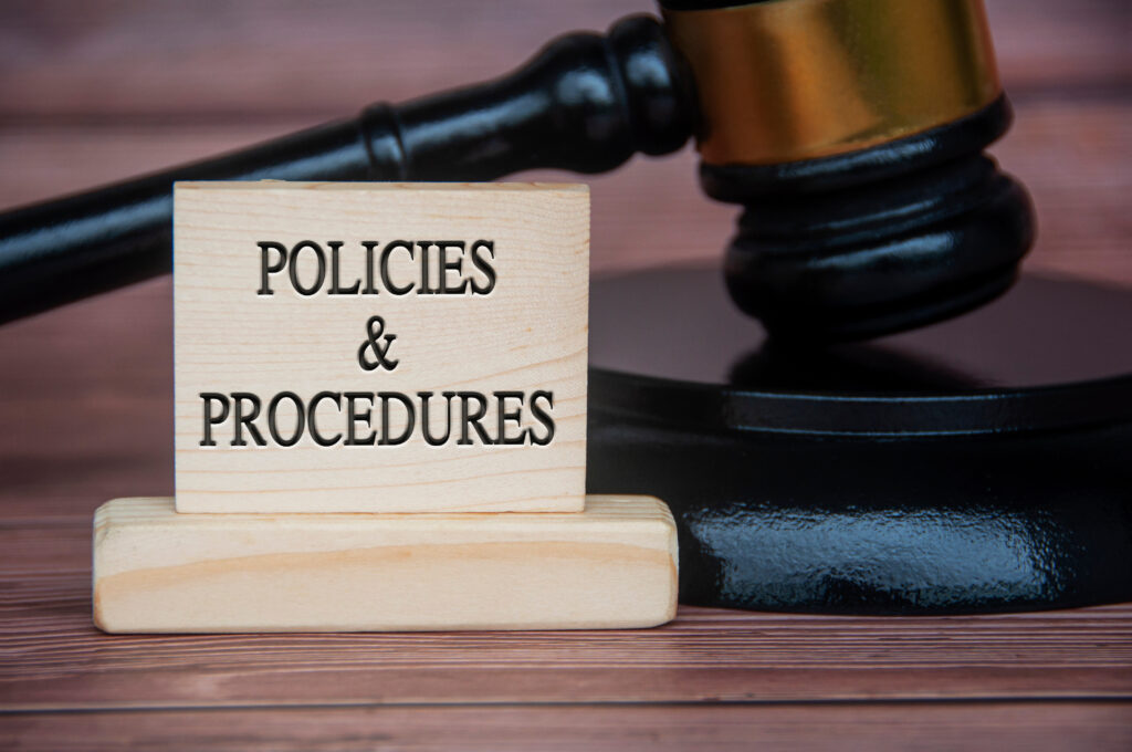 Policies and procedures text engraved on wooden block with gavel